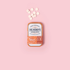 Orange Relax tin with 2:1 CBD and THC mints on pink background